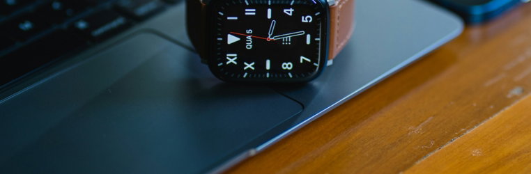 an apple watch sitting on top of a laptop computer