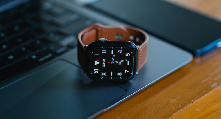 an apple watch sitting on top of a laptop computer